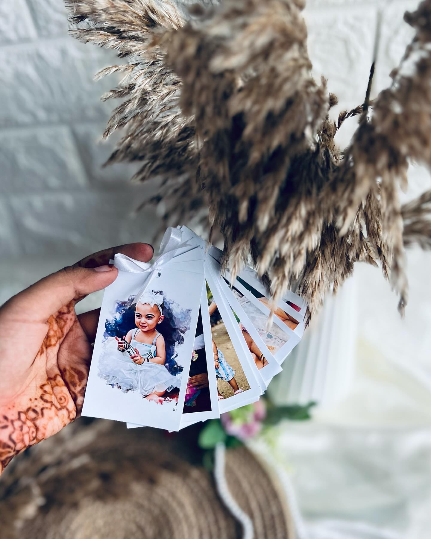 A ribbon-tied fan of custom printed photo cards capturing cherished moments, a sweet personalized keepsake.