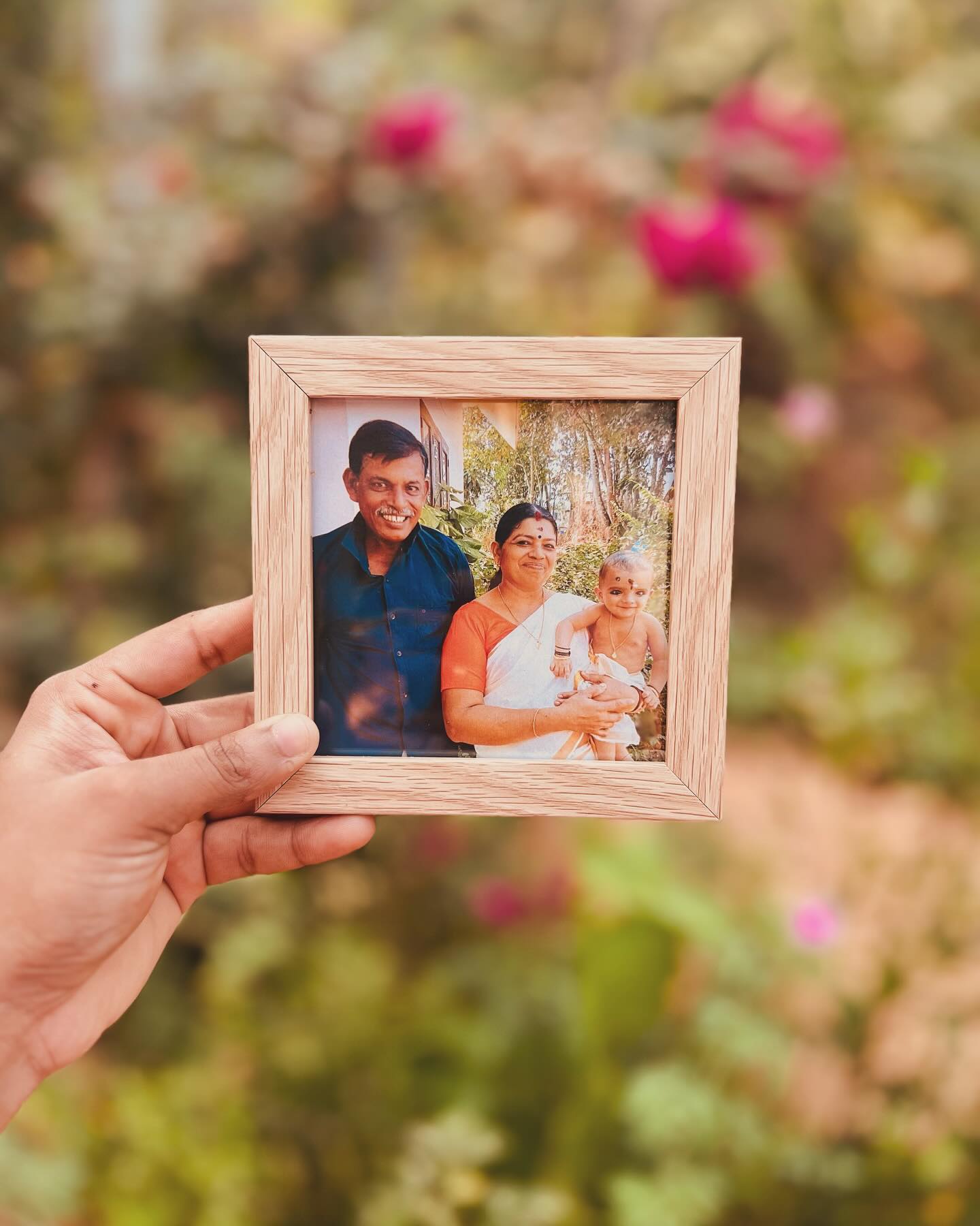 A small light-wood photo frame showcasing a cherished family portrait.