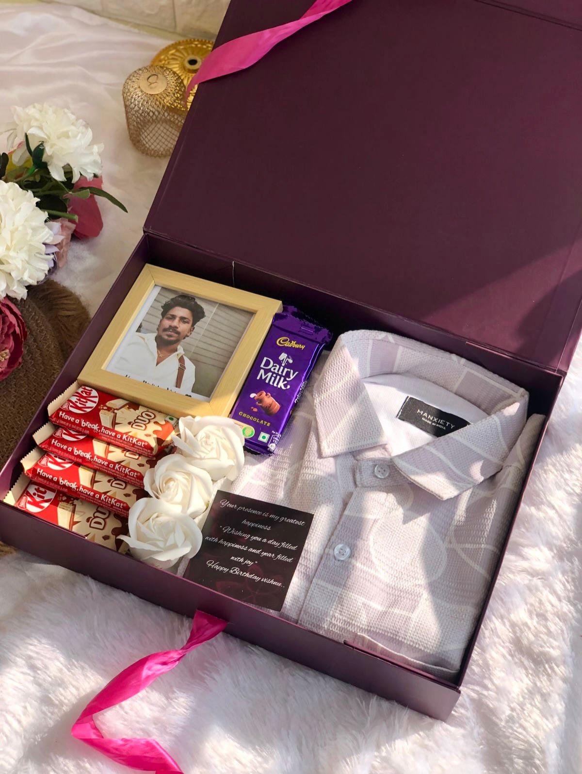 A wine-toned birthday box with a photo frame, chocolates, roses, and a heartfelt printed note.