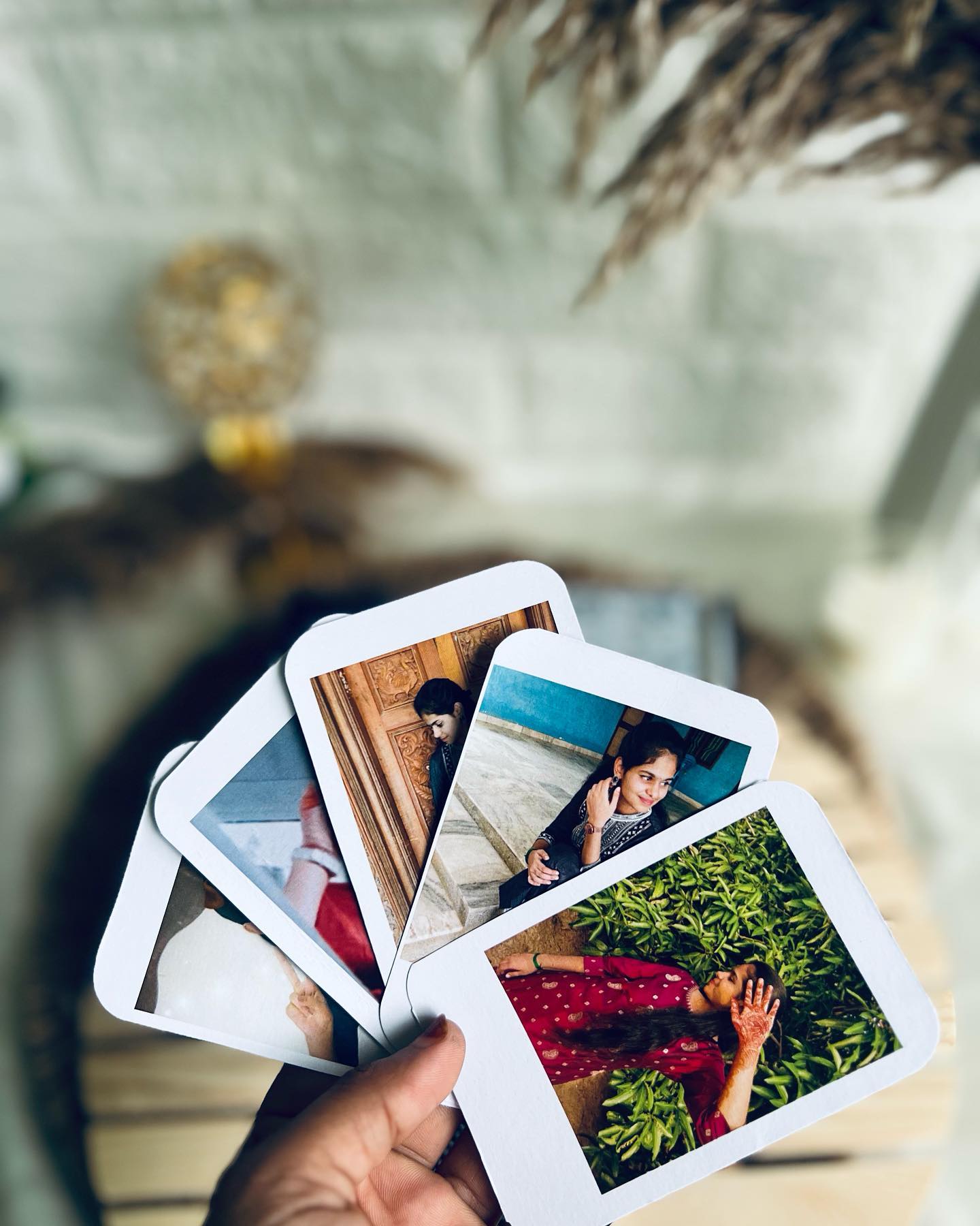 An open black gift box with a personalized photo frame and KitKat chocolate, accompanied by a heartfelt note card and a fan of Polaroid-style photo cards.