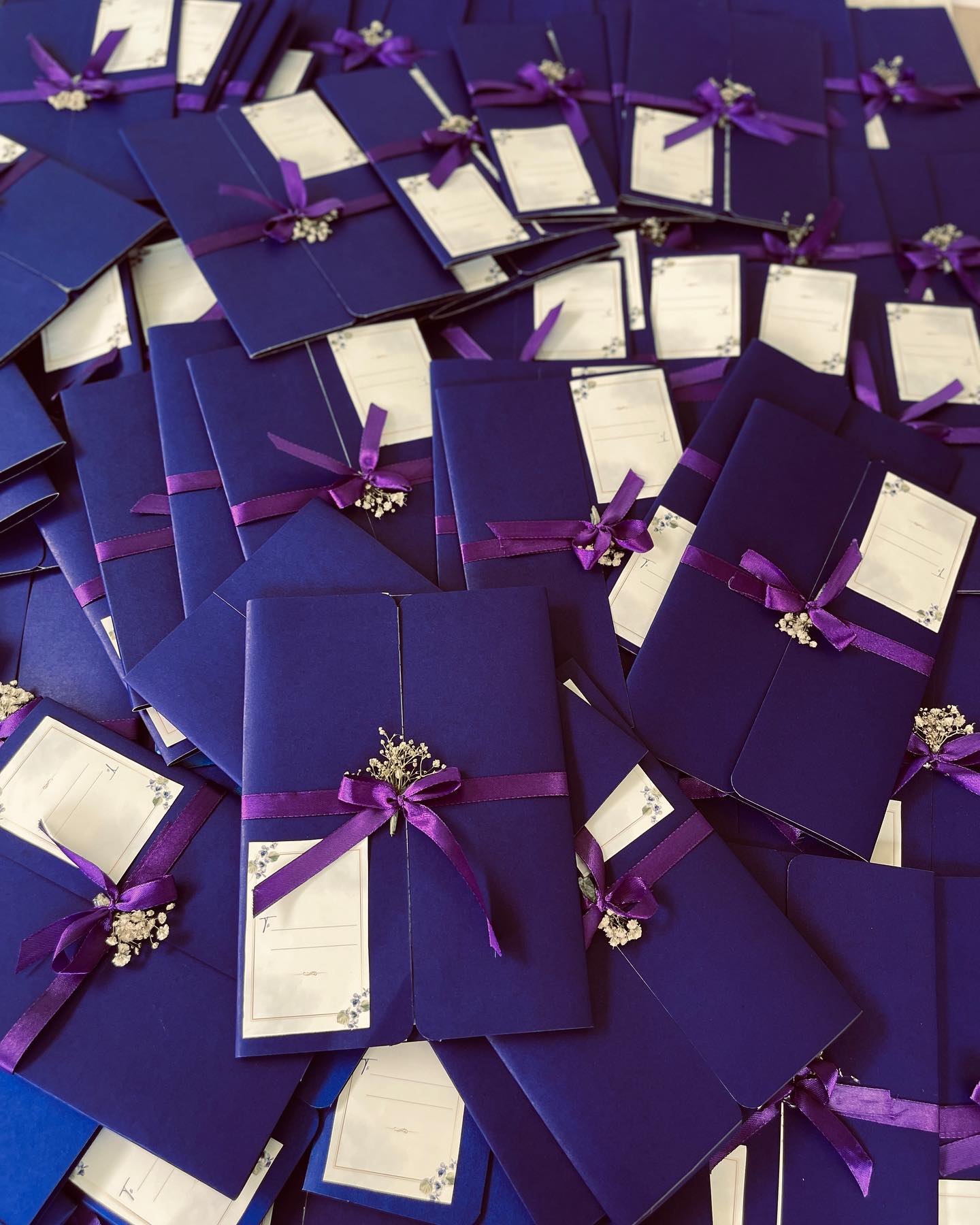 A set of deep purple gift pouches tied with satin ribbon and baby's breath, ready for guest favors.