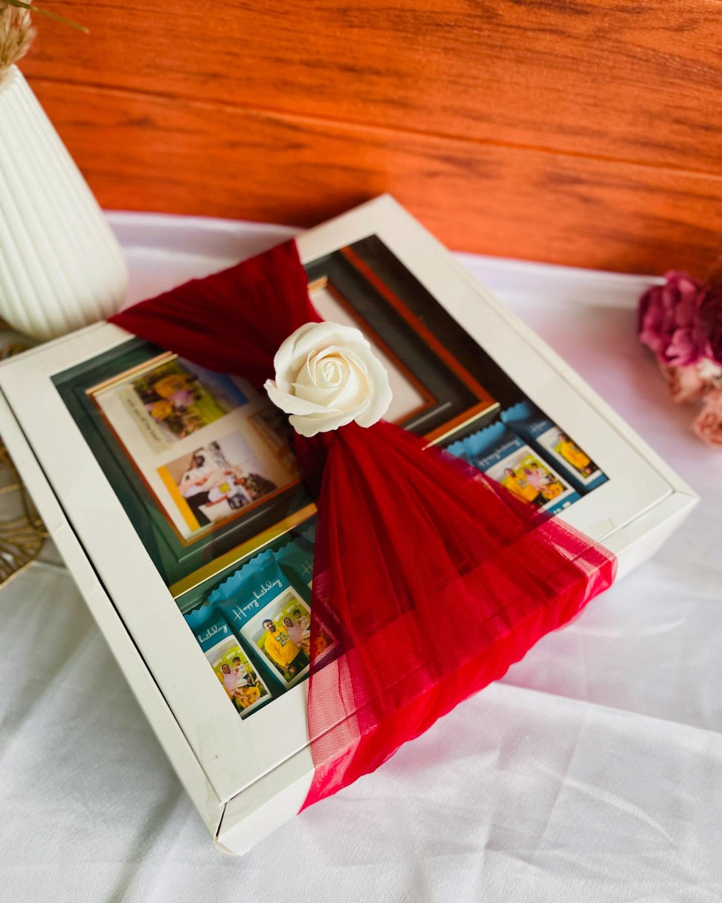 A birthday keepsake box wrapped in red tulle with a foam rose, featuring a photo frame and personalized birthday photo treats.