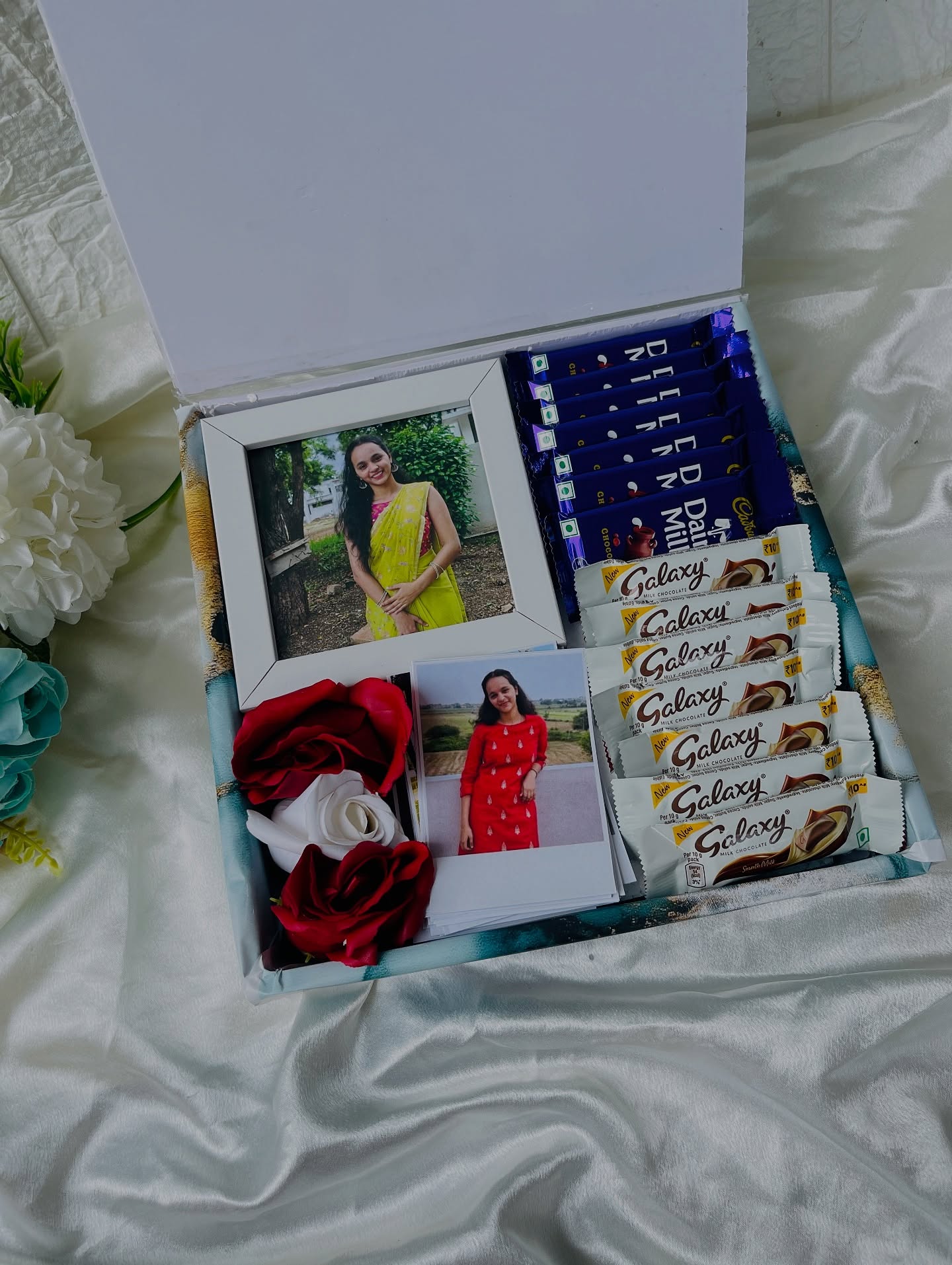 A personalized keepsake box layered with photo prints, roses, and a generous mix of Cadbury and Galaxy chocolates.