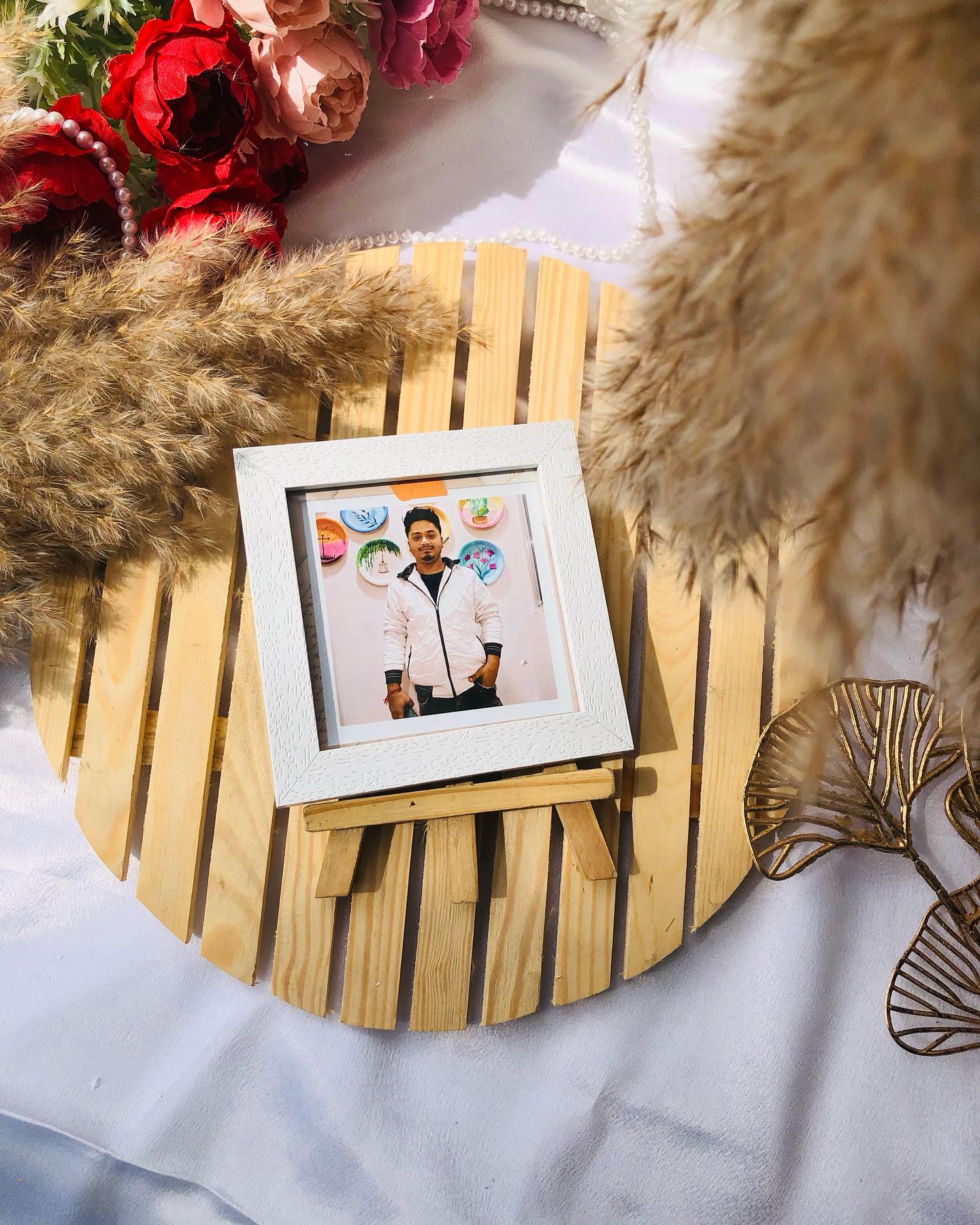 A custom photo print in a white textured frame, displayed on a charming wooden rocking easel stand.