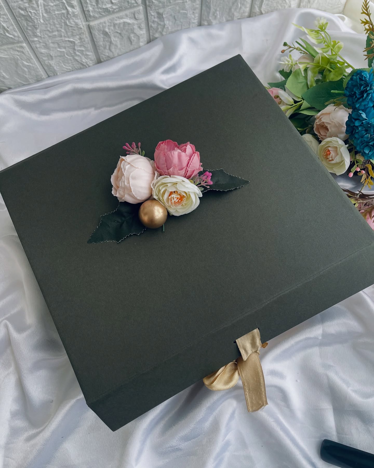 A teal embroidered saree paired with jewelry, chocolates, and roses in a keepsake box.