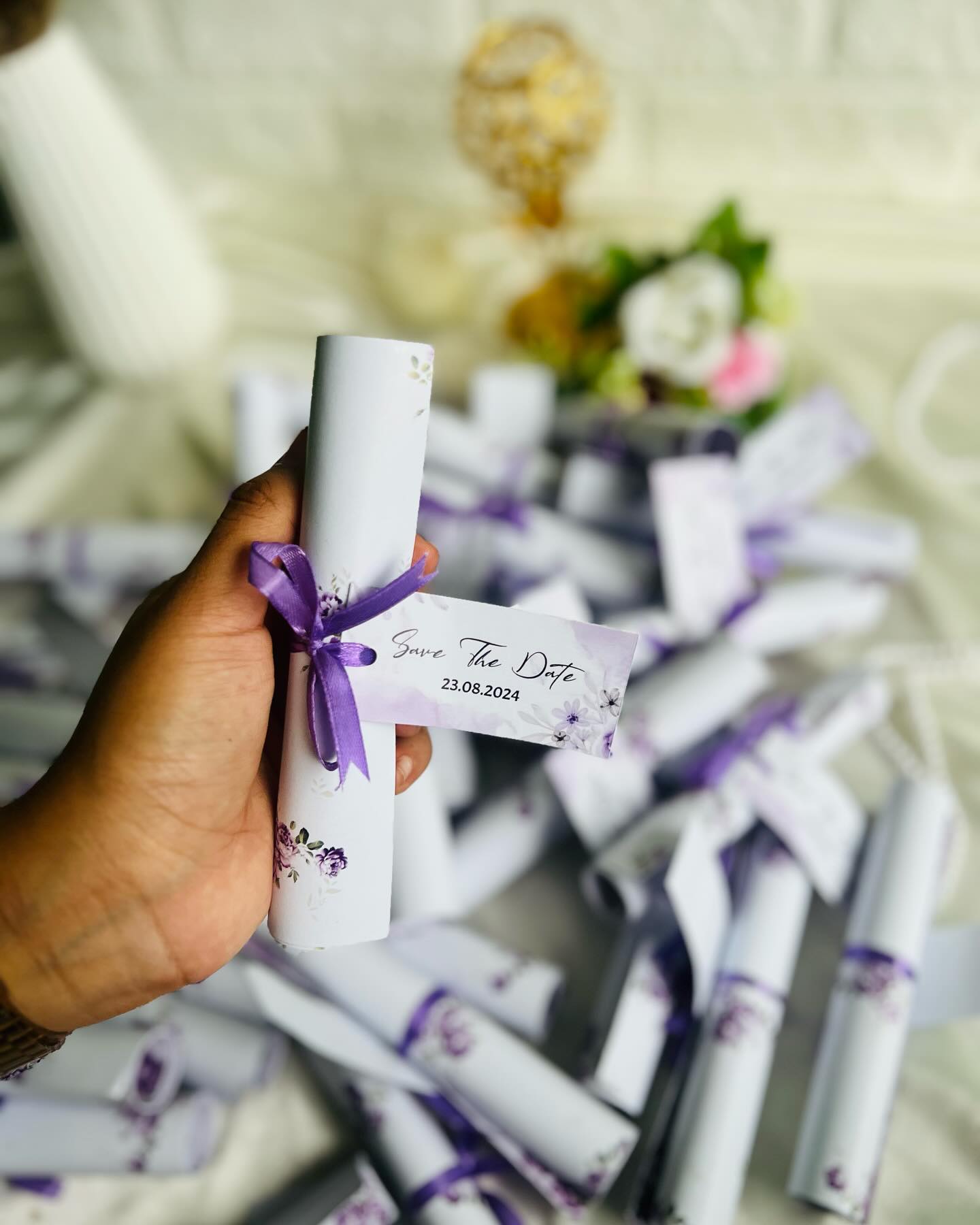 Elegant purple floral scroll invitations tied with satin ribbon, personalized with the wedding date.