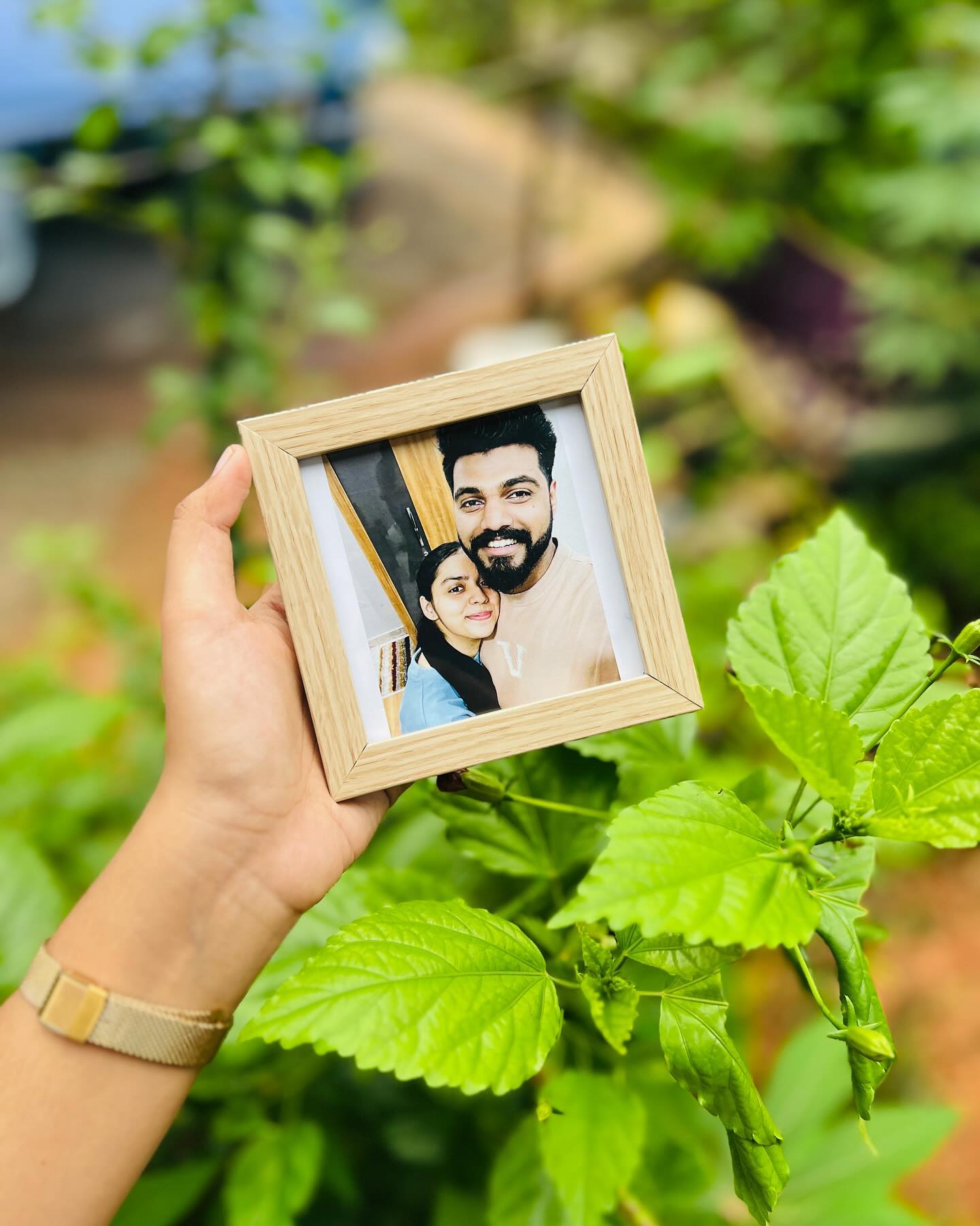 A rustic wooden photo frame personalized with a warm couple selfie.