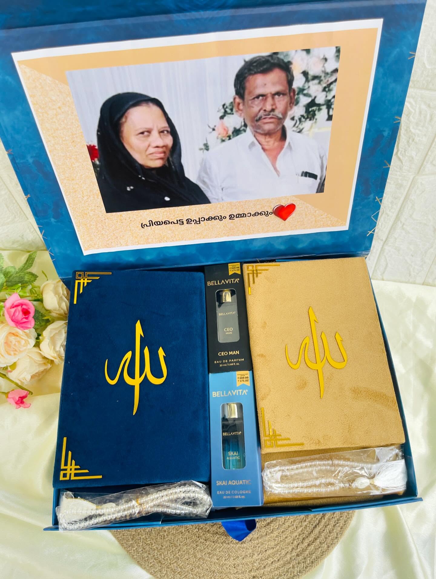 An elegant navy and gold gift box for parents with velvet Allah-motif covers, two Bellavita perfumes, and a pearl tasbih.