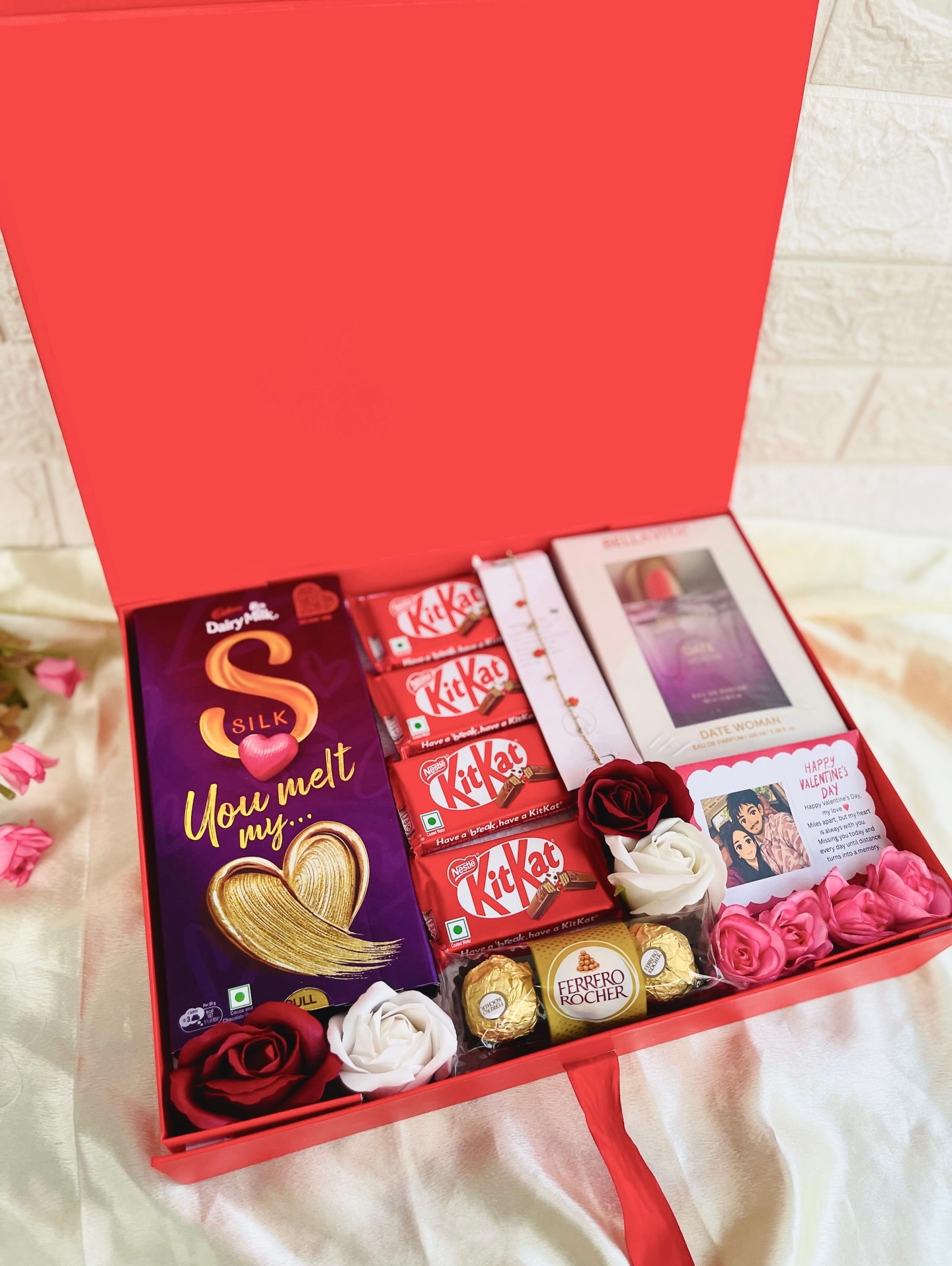 A romantic red gift box loaded with Dairy Milk Silk, KitKat, Ferrero Rocher, a bracelet, perfume, and a personalized love note.