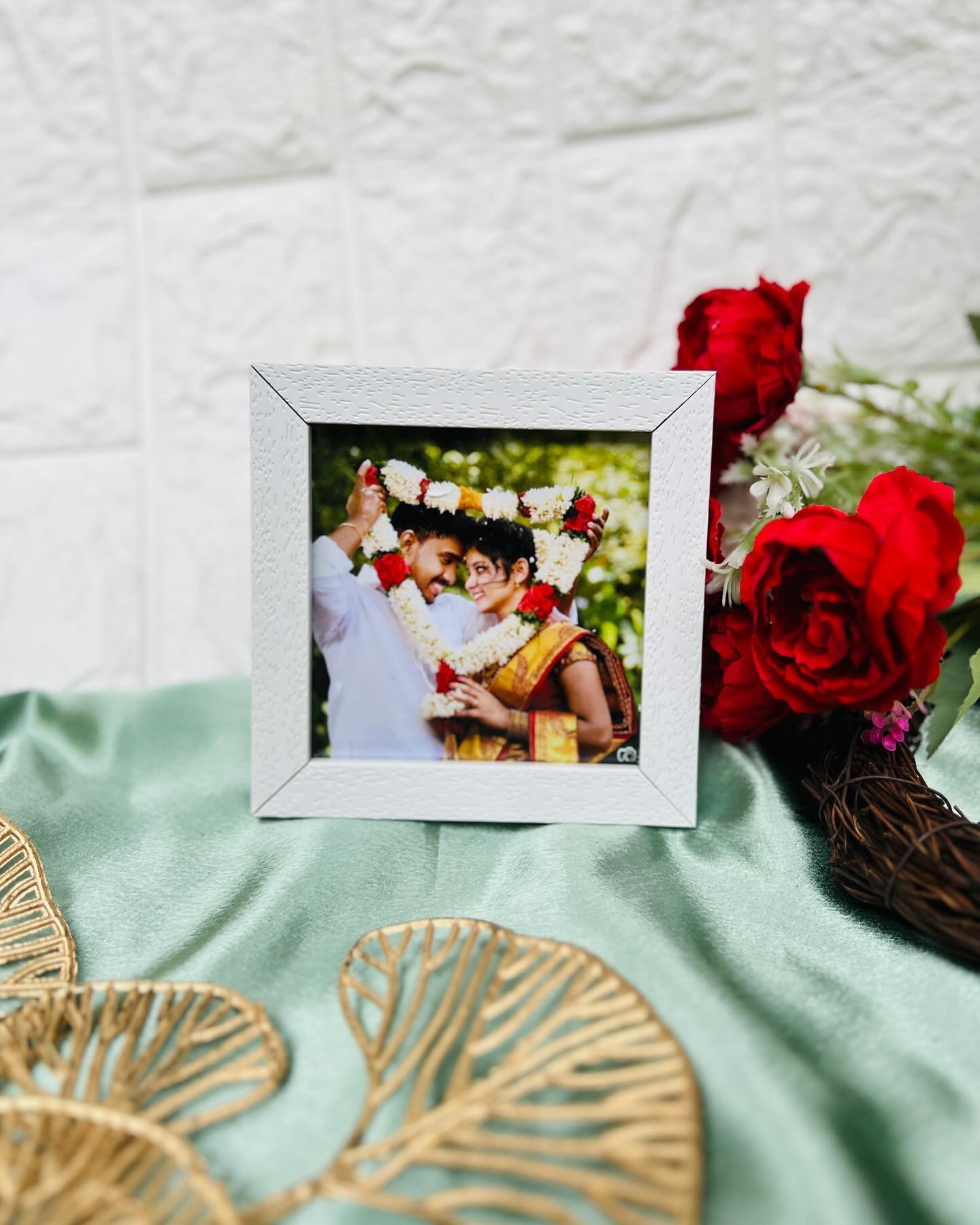 A classic white photo frame showcasing a cherished wedding garland-exchange moment.