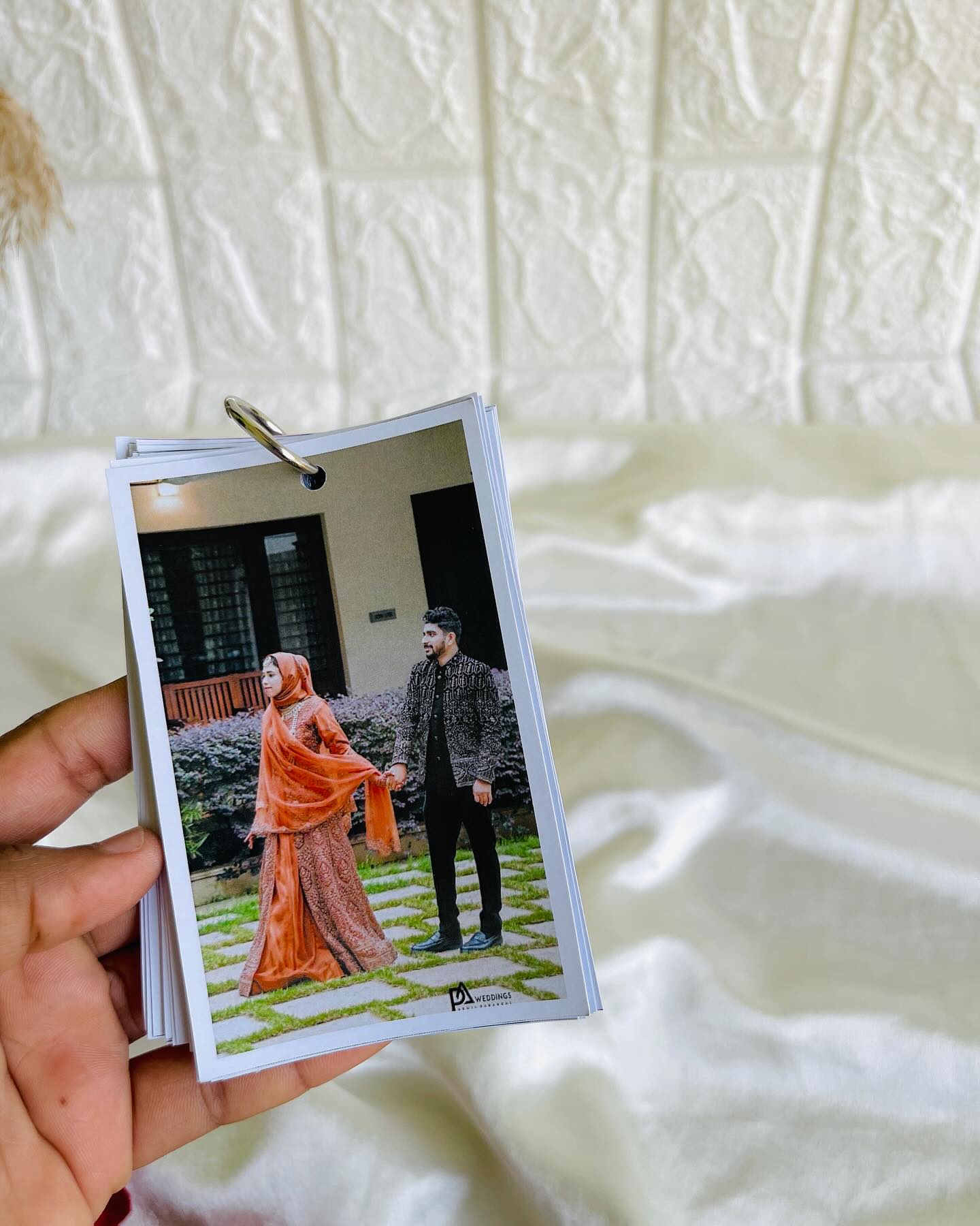 A compact ring-bound flip album of wedding photographs, a keepsake for reliving the big day.