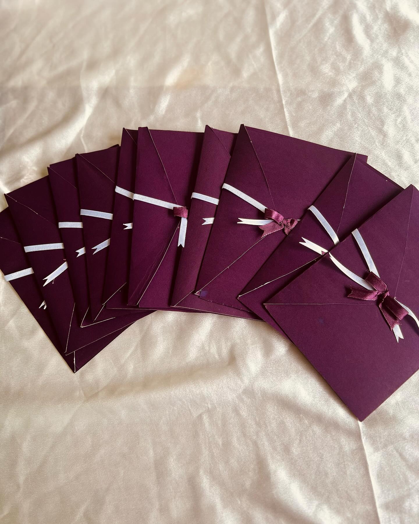 A rich plum gift envelope tied with a satin bow, ideal for slipping in cash or a small surprise.